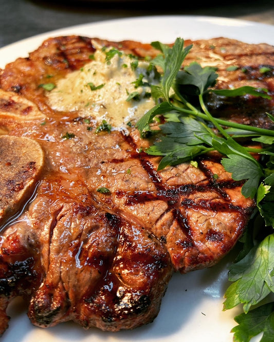 Grilled Ribeye Steak. Perfectly seasoned and finished with steak butter. Close up image.
